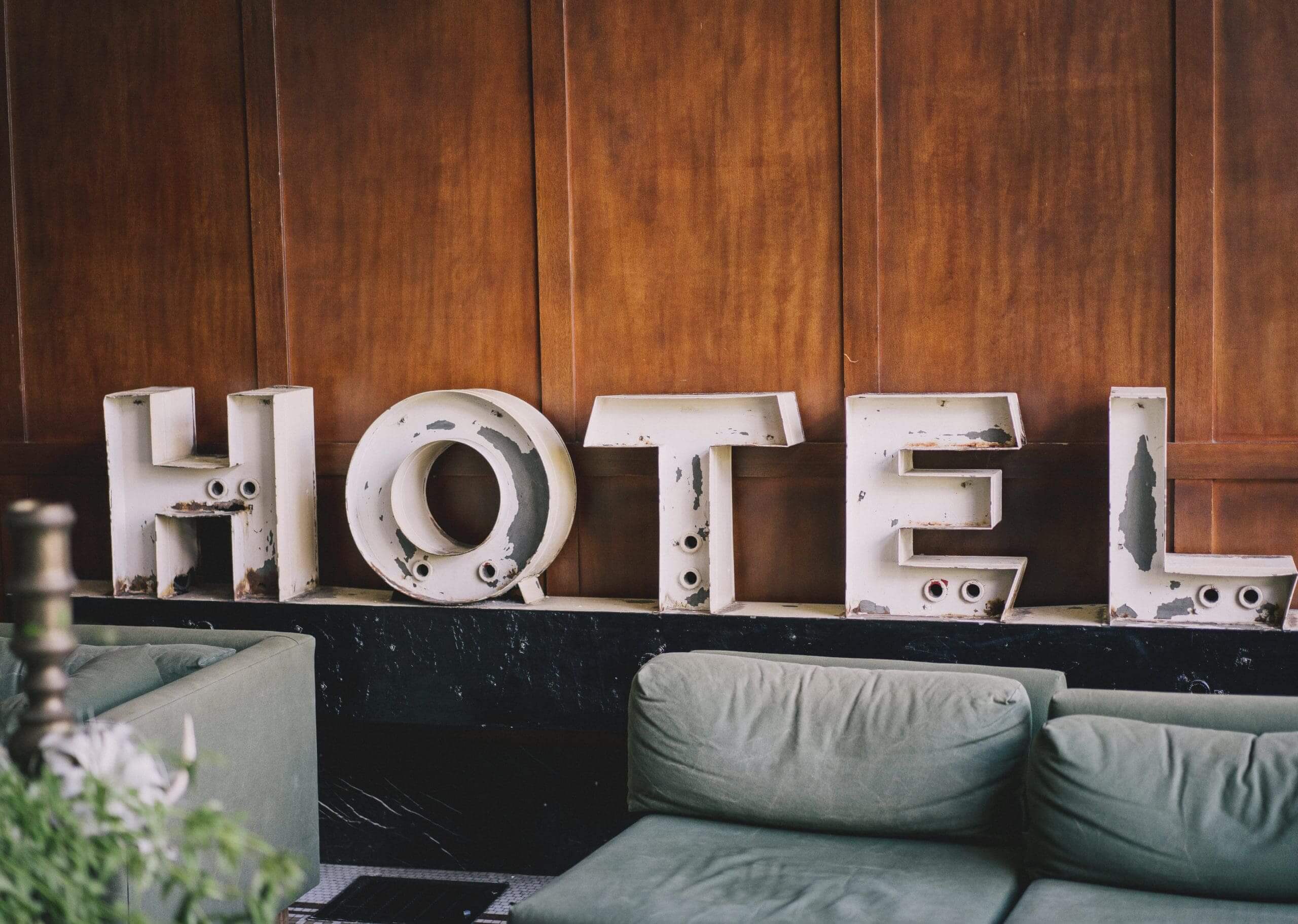 Old metallic Hotel sign behind a sofa